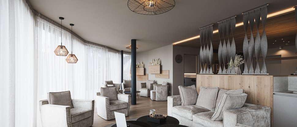 Ultime novità e storie da Valdaora Soggiorno moderno con poltrone chiare, divano e lampade a sospensione