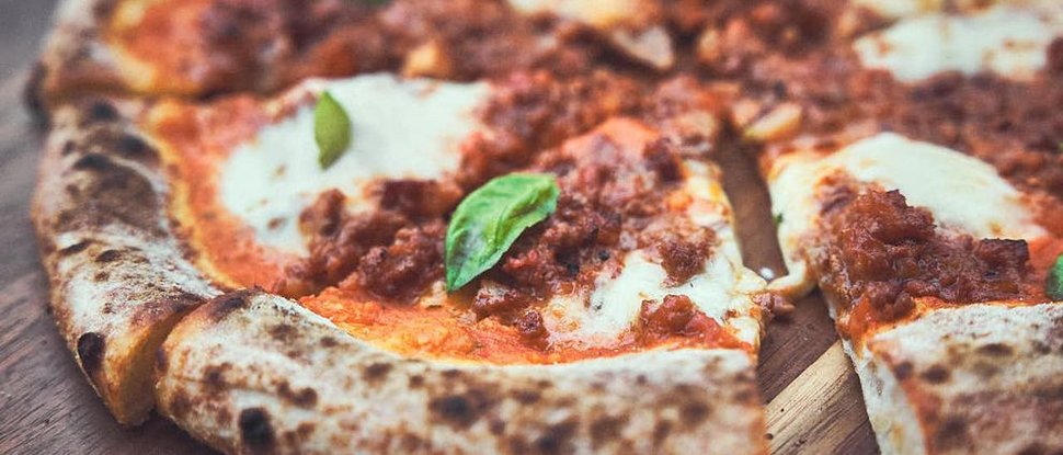Ultime novità e storie da Valdaora Pizza con salsa di pomodoro, mozzarella e basilico su tavolo di legno