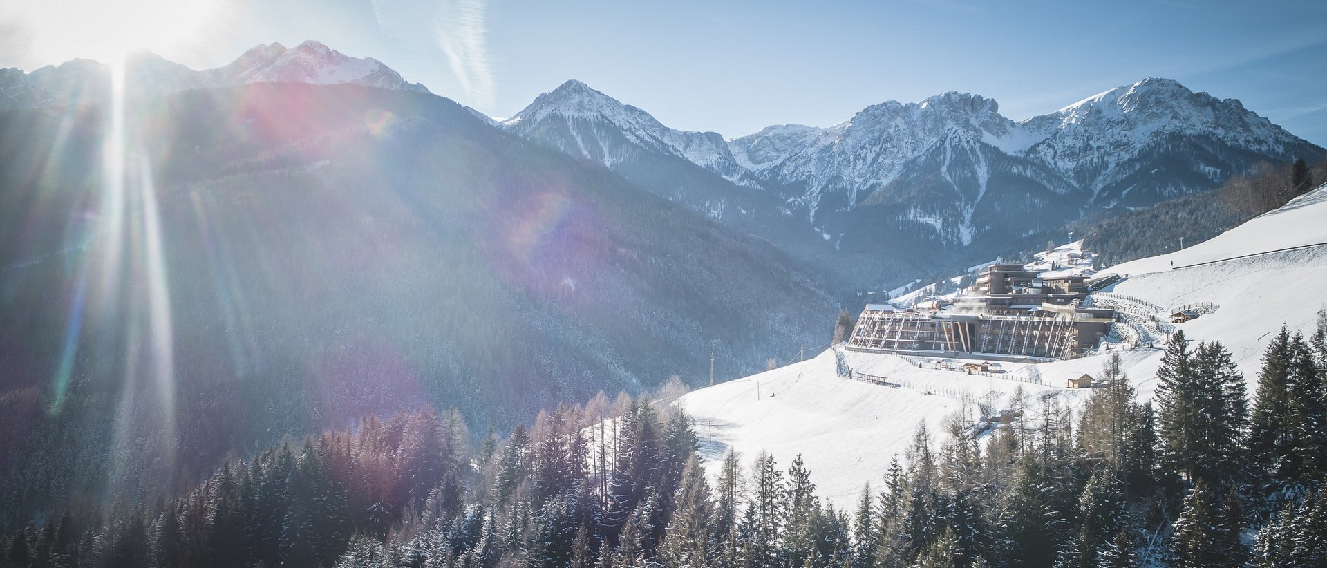 Hotel a 5 stelle in Val Pusteria Giornata invernale soleggiata in montagna con neve, bosco e edificio