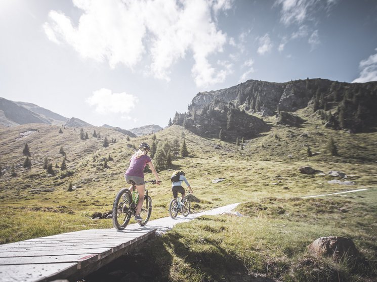 Escursioni sul Plan de Corones: uniche Due ciclisti in mountain bike percorrono un sentiero di montagna al sole