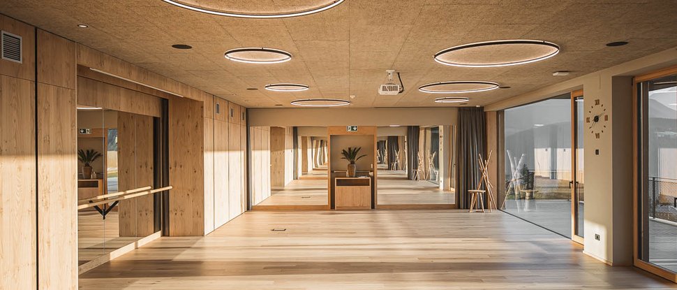 Ultime novità e storie da Valdaora Ampia stanza luminosa con pavimento in legno, specchio e luci circolari a soffitto