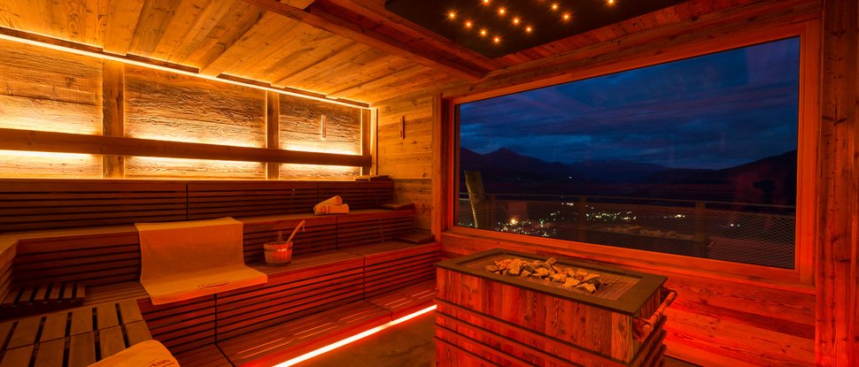 Ultime novità e storie da Valdaora Sauna in legno con vista sulle montagne di notte e illuminazione d'atmosfera