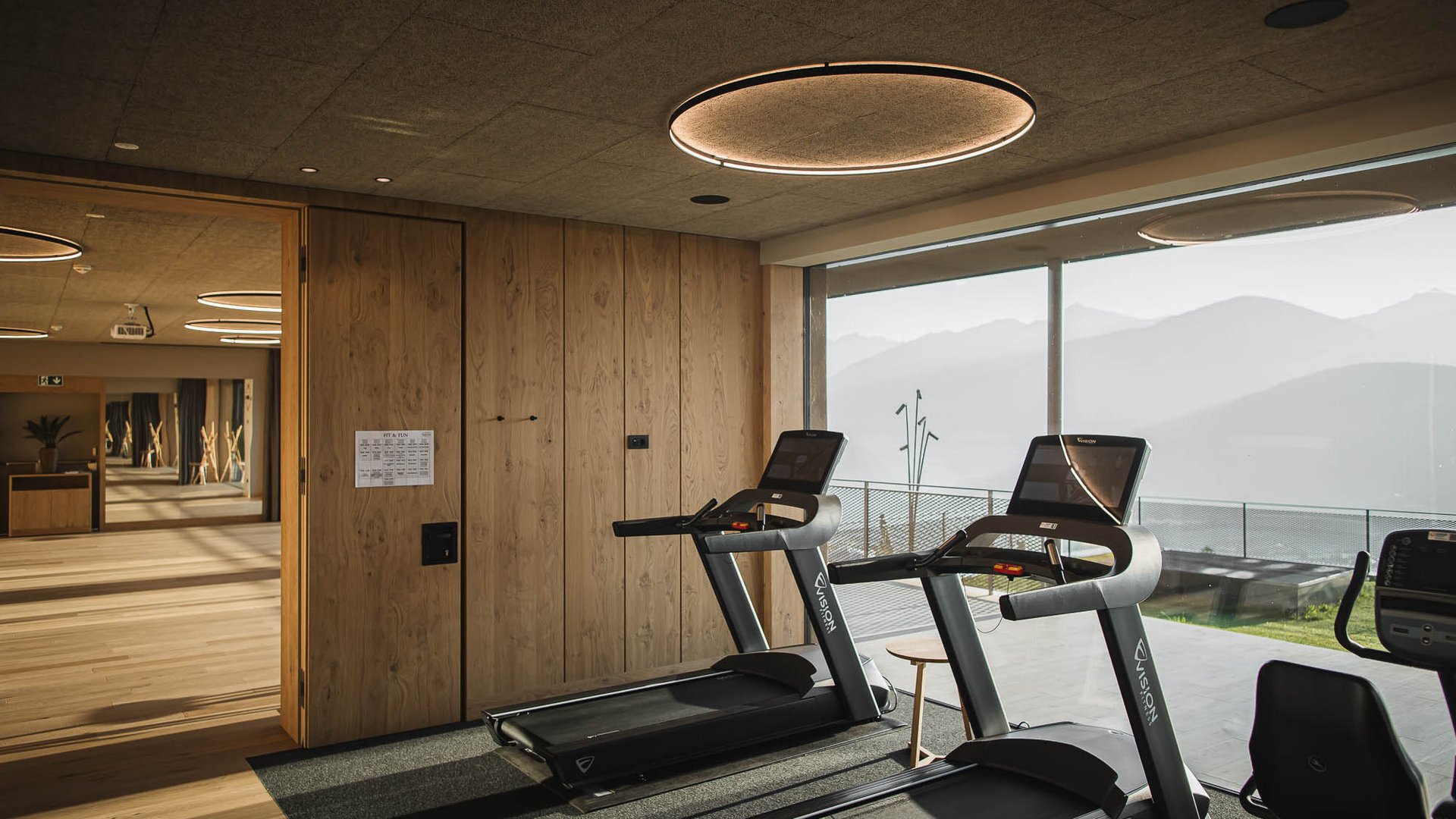 Il nostro hotel con palestra in Val Pusteria Sala fitness moderna con tapis roulant e vista panoramica sulle montagne