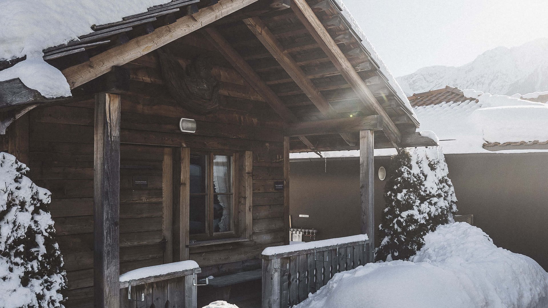 Le nostre saune in Val Pusteria vicino al Plan de Corones Baita di legno innevata con terrazza in una giornata invernale soleggiata