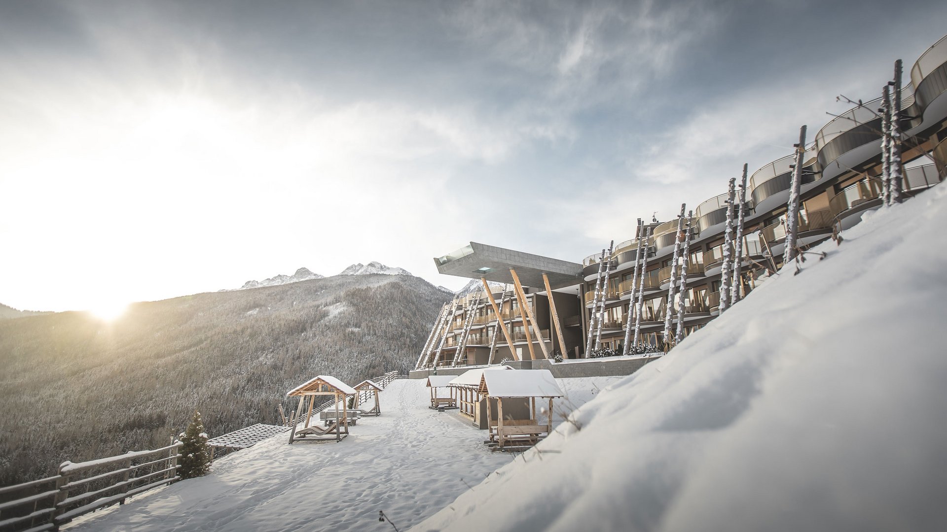 Hotel moderno sulla montagna innevata con alba e montagne sullo sfondo