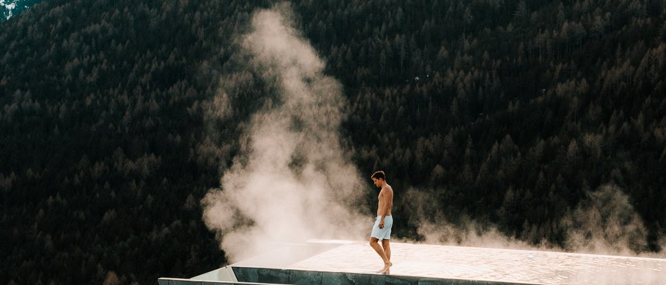 Ultime novità e storie da Valdaora Uomo sul bordo di una piscina a sfioro fumante in montagna
