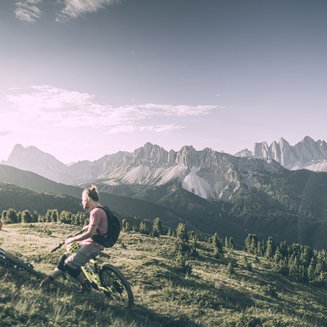 Escursioni sul Plan de Corones: uniche Due mountain biker si riposano su un prato con panorama montano alle spalle
