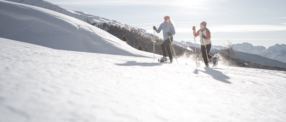 Ultime novità e storie da Valdaora Due persone camminano con le racchette da neve nella neve soleggiata in montagna