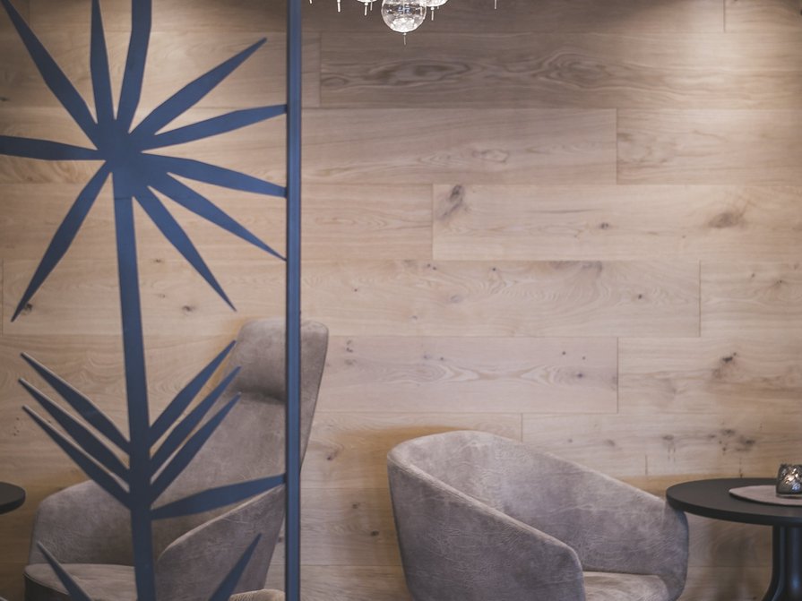 Il nostro hotel a Valdaora tra cielo e terra Angolo accogliente con parete beige, poltrone grigie e lampada a soffitto