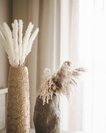 Ultime novità e storie da Valdaora Due vasi decorativi con erba pampas essiccata davanti a tende