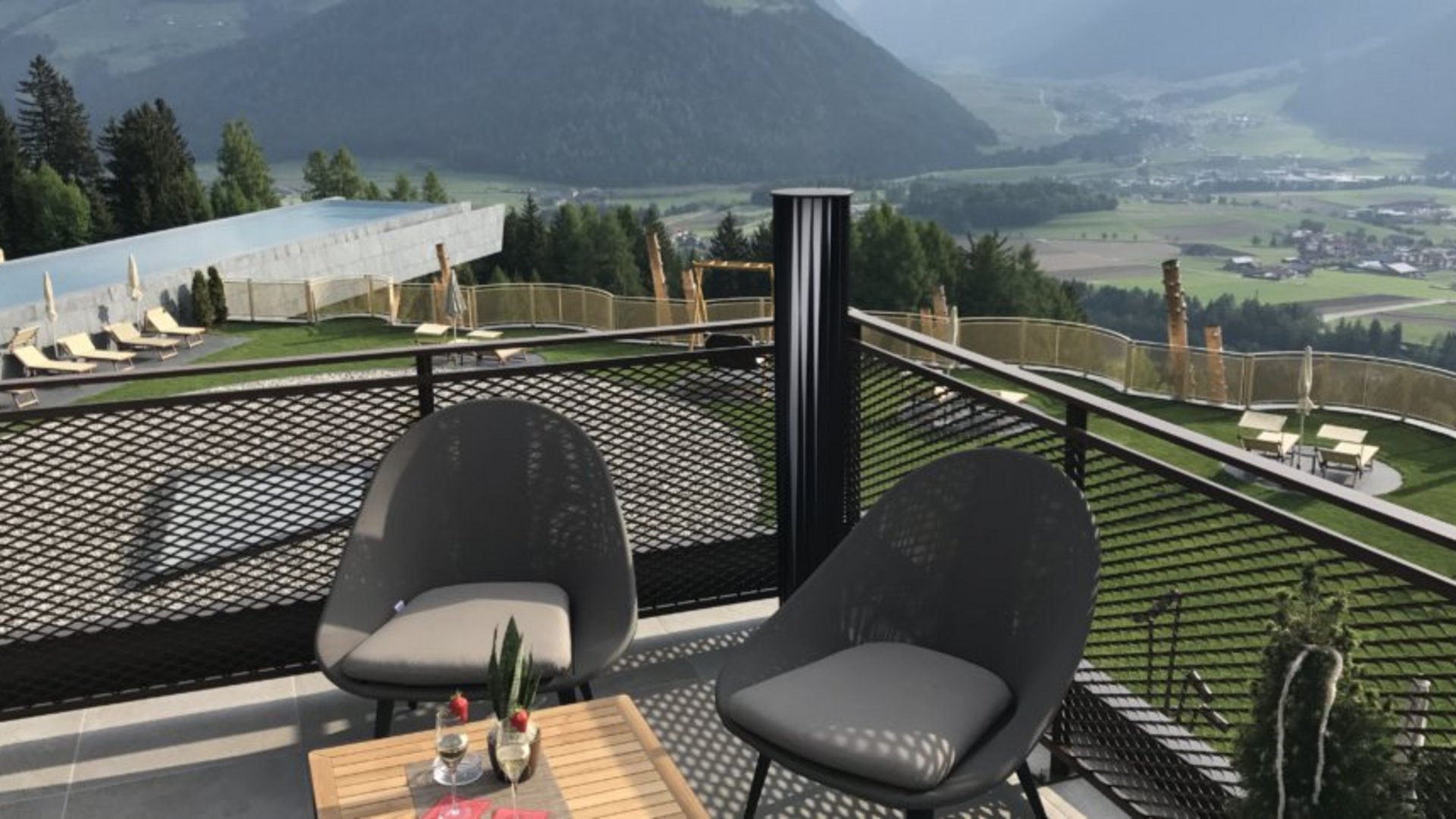 Il regno del gusto Balcone con due sedie moderne e vista sulle montagne in giornata di sole