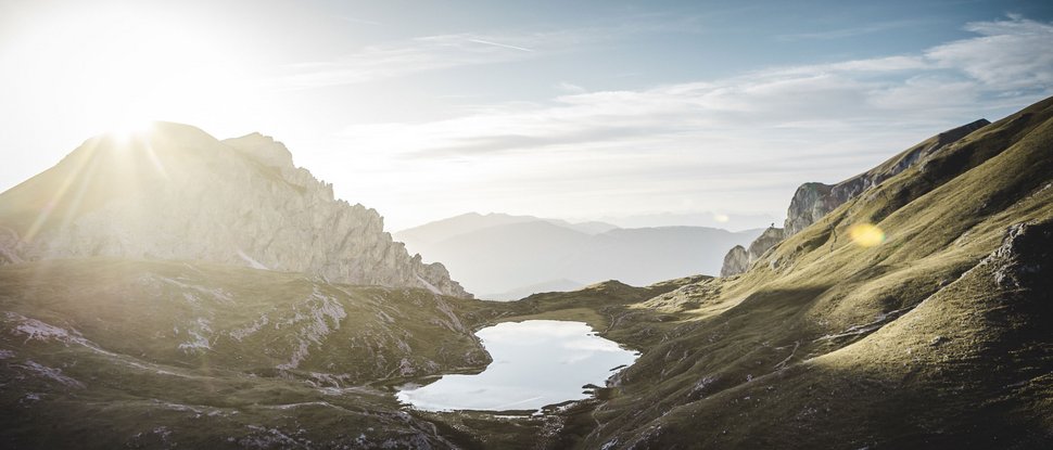 Ultime novità e storie da Valdaora Alba sopra un lago di montagna in un paesaggio verde collinare