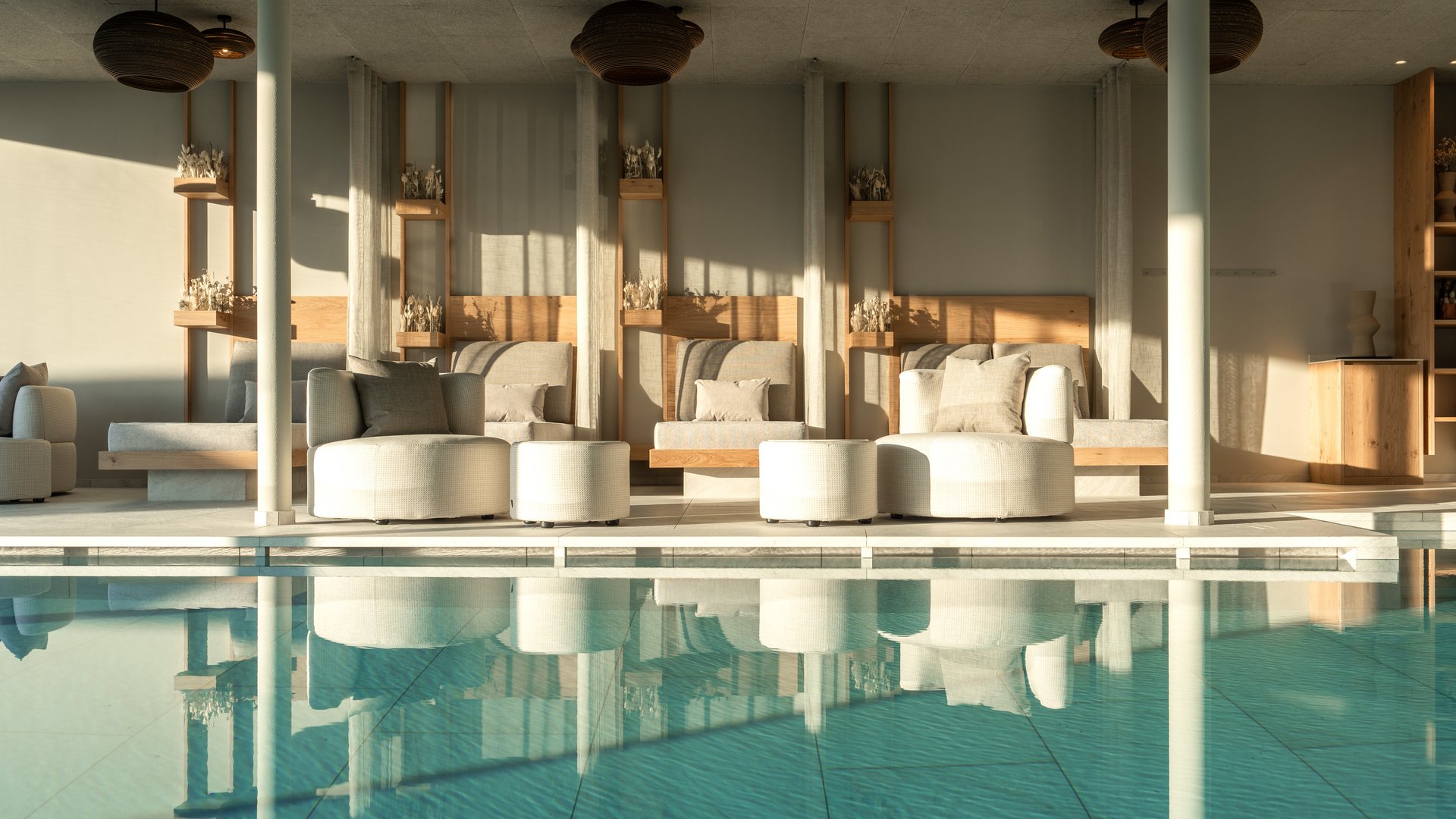 Il nostro hotel con infinity pool in Alto Adige: una meraviglia Salotto luminoso con piscina e comodi posti a sedere dal design moderno
