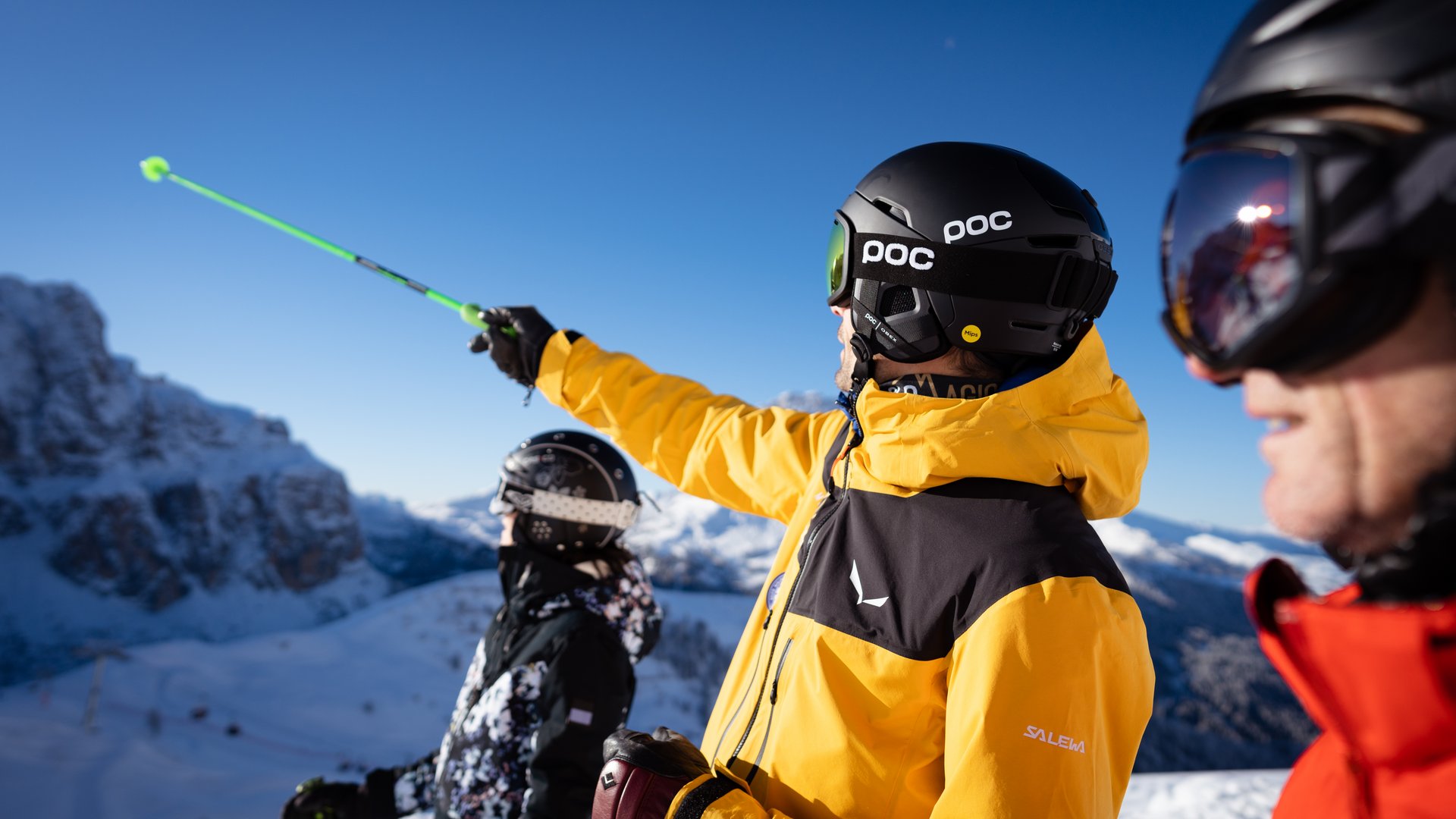 Il miglior hotel sulle piste al Plan de Corones Sciatori con abbigliamento colorato e casco indicano montagne innevate