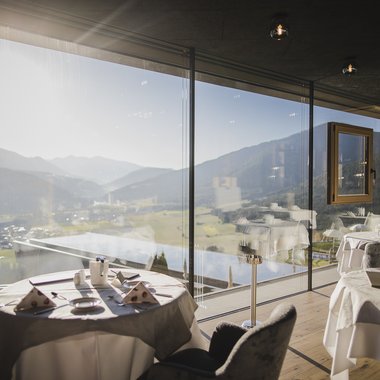 Vivere piaceri culinari stellati Ristorante con tavoli e vista sulle montagne attraverso finestre di vetro