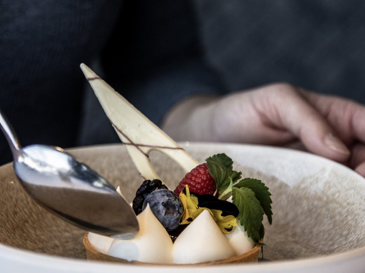 Vivere piaceri culinari stellati Dessert elegante con frutti di bosco e panna in piatto bianco