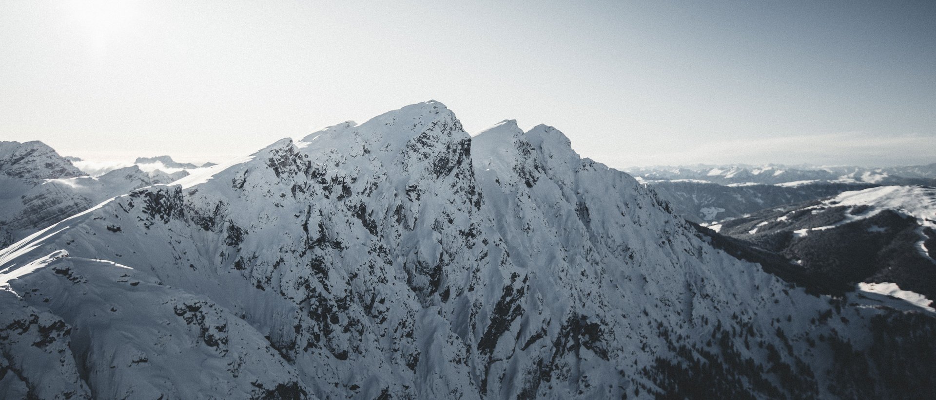 Il vostro hotel al Plan de Corones a 5 stelle Montagna coperta di neve con cielo soleggiato e valle ampia sullo sfondo