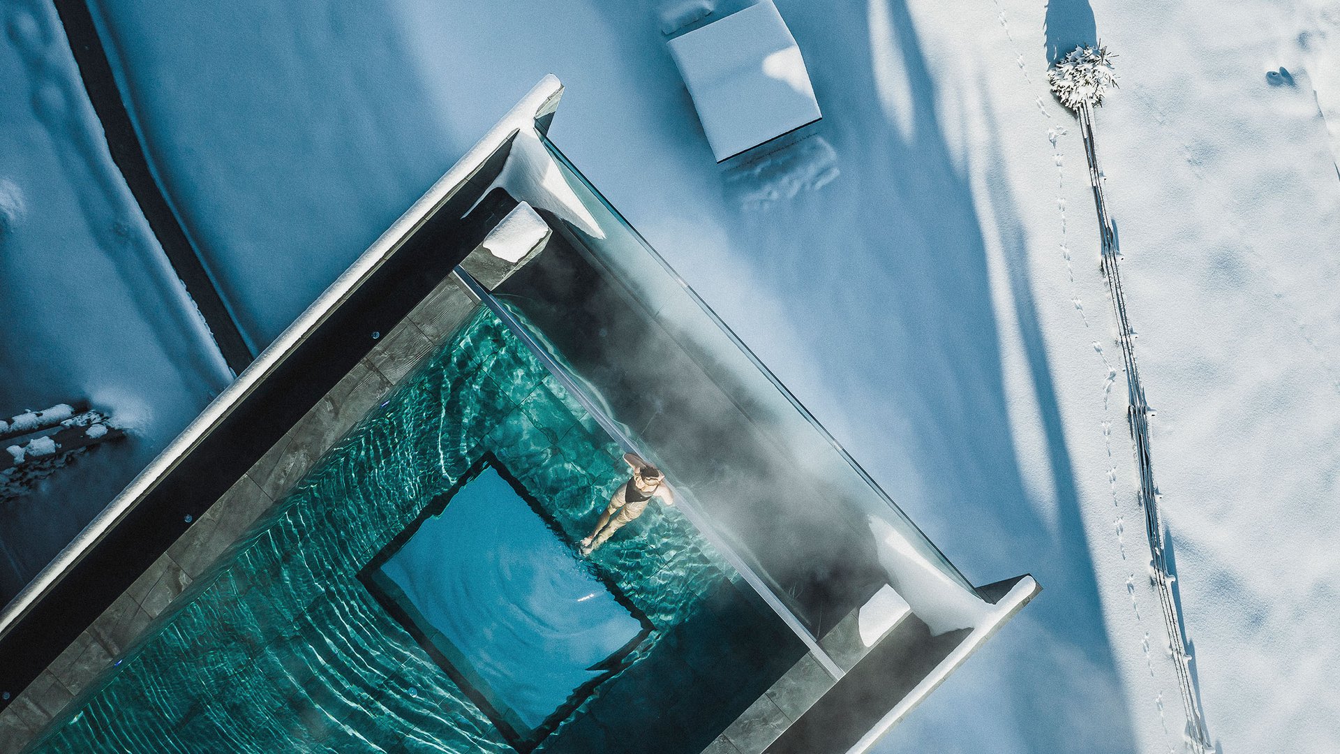 Ultime novità e storie da Valdaora Persona che nuota in piscina riscaldata circondata da neve e paesaggio invernale