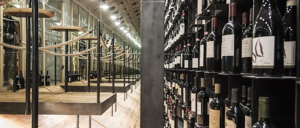 Ultime novità e storie da Valdaora Cantina con molte bottiglie di vino e rivestimento in legno