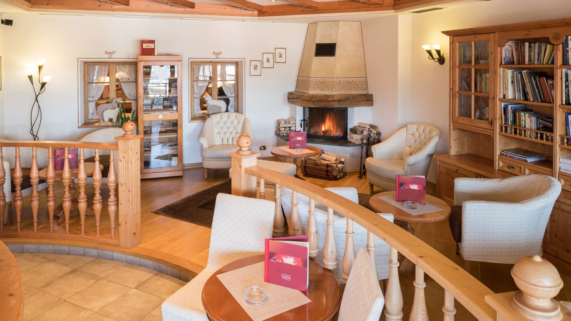 Il regno del gusto Area salotto accogliente con camino, poltrone e libreria in legno