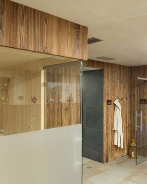 Hotel in Val Pusteria con spa per il vostro relax Area sauna moderna con rivestimenti in legno e bagno turco con illuminazione blu