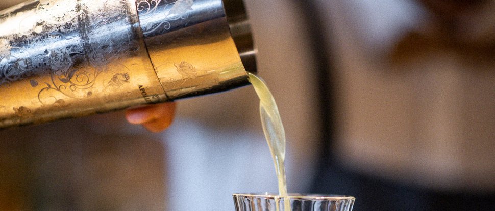 Ultime novità e storie da Valdaora Un barista versa una bevanda verde da uno shaker in un bicchiere di cristallo