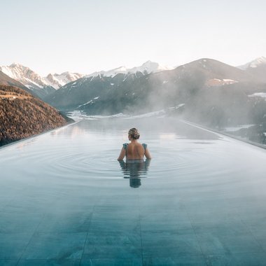 Il nostro programma invernale Donna in piscina a sfioro riscaldata con vista sulle montagne