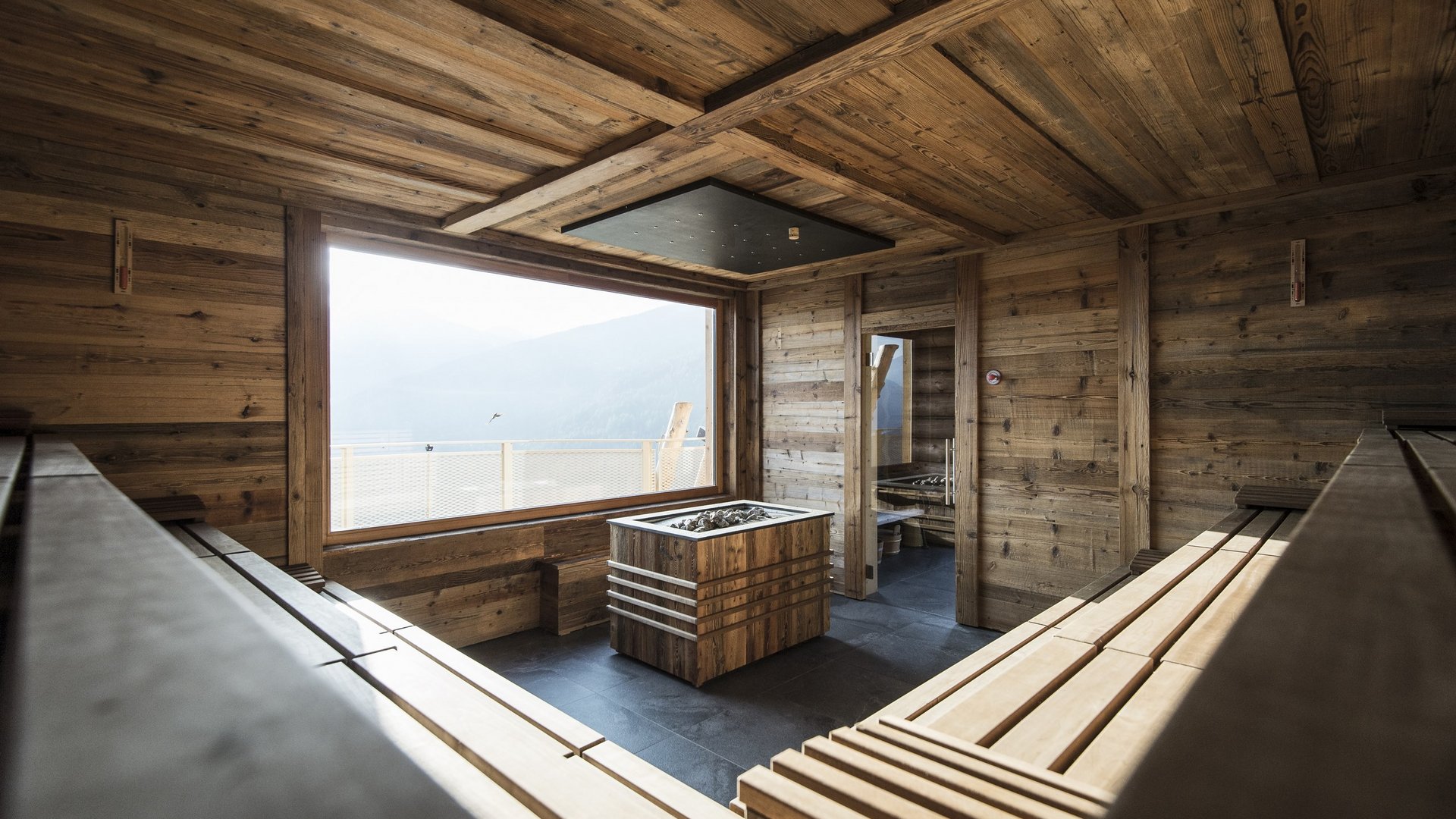 Hotel in Val Pusteria con spa per il vostro relax Sauna in legno con grande finestra e vista sulle montagne