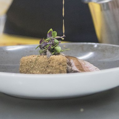 L'Hubertus in un breve lasso di tempo Piatto raffinato con salsa versata su carne impanata e erbe