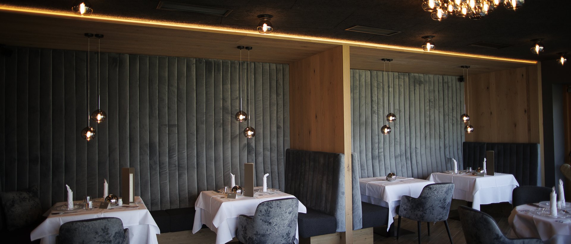 Hotel gourmet in Alto Adige per buongustai Lounge di ristorante moderna con illuminazione soffusa e tavoli eleganti