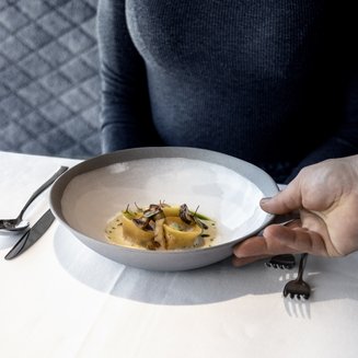 Vivere piaceri culinari stellati Donna riceve piatto con pasta raffinata e funghi al ristorante