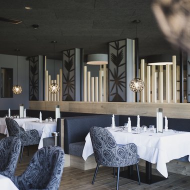 Hotel gourmet in Alto Adige per buongustai Ristorante elegante con tavoli apparecchiati e arredi moderni