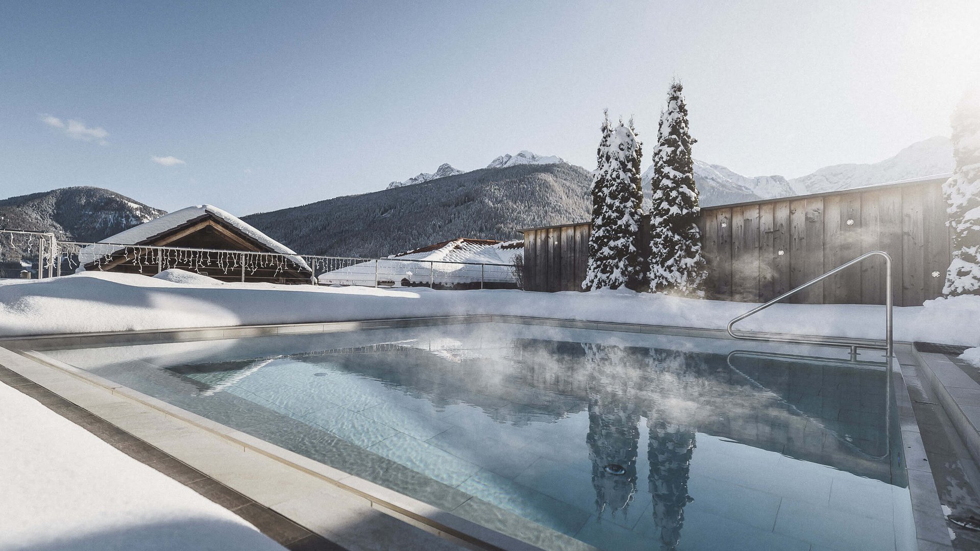 Il nostro hotel con infinity pool in Alto Adige: una meraviglia Piscina esterna riscaldata circondata da neve con montagne sullo sfondo