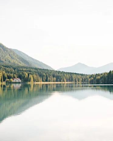 Ultime novità e storie da Valdaora Lago di montagna con alberi riflessi e casa sulla riva