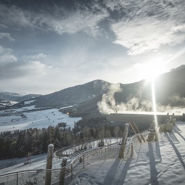 Awards & Press Winterlandschaft mit sonnigem Himmel und dampfendem Gebäude auf einem Berg