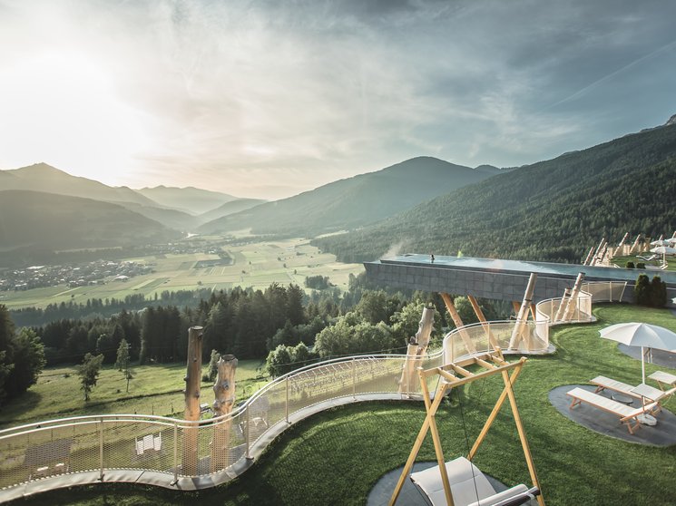 Unser Hotelgutschein: Südtirol im Geschenkformat Blick auf Terrasse mit Schwimmbecken und Alpenpanorama bei Sonnenuntergang