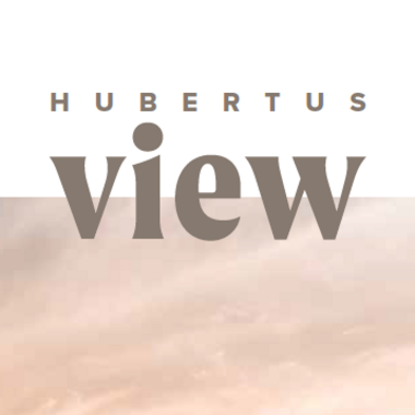 Unser aktueller Katalog zum Downloaden Zwei Personen am Infinity-Pool mit Blick auf Berge und Sonnenuntergang