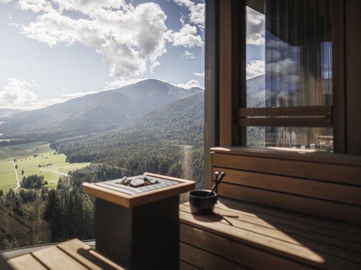 Das Wellnesshotel im Pustertal zum Entspannen Sauna mit Panoramablick auf bewaldete Berge und Tal