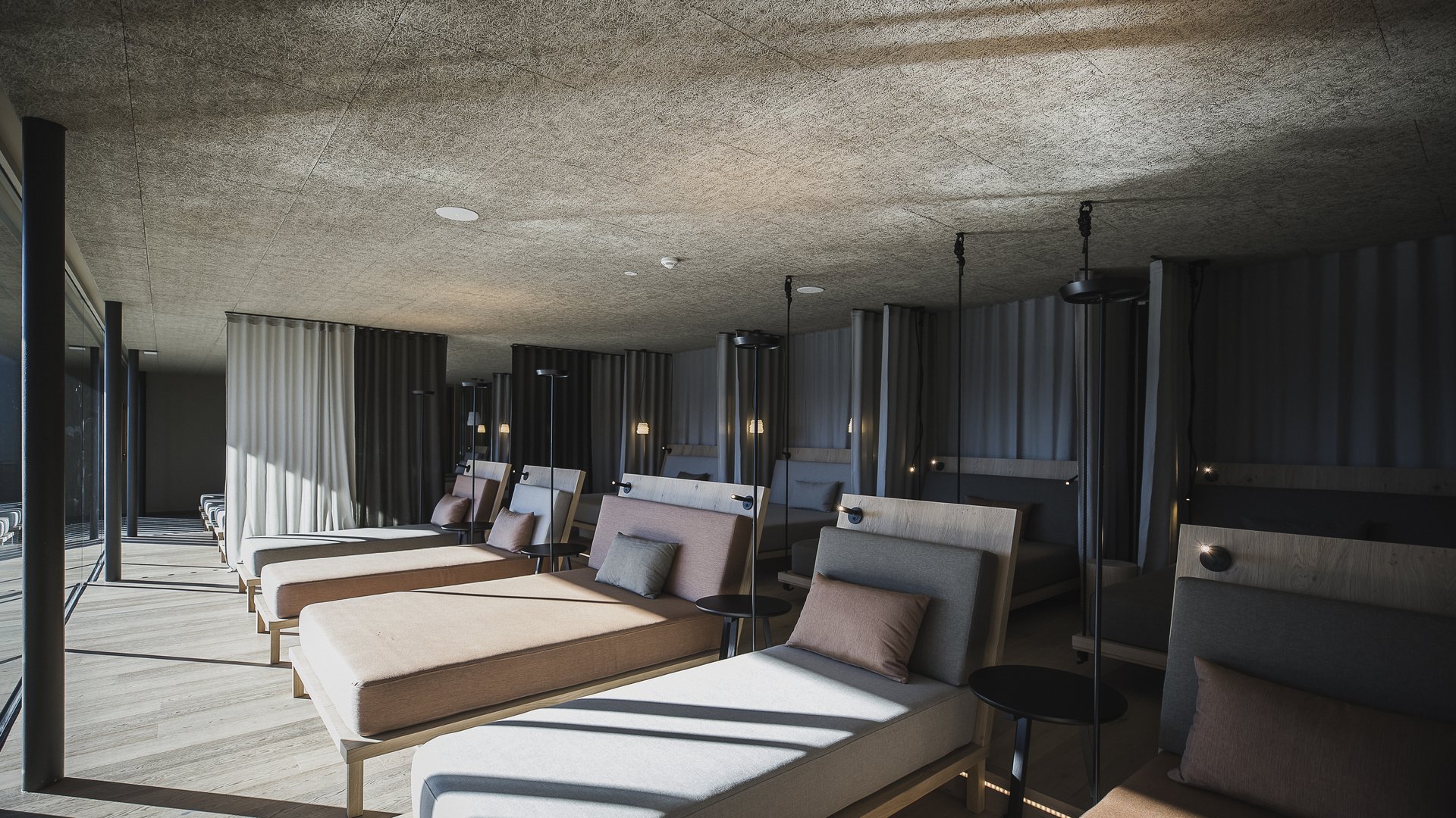 Unsere Sauna, den Kronplatz im Blickfeld Moderne Lounge mit mehreren gepolsterten Liegen und Tageslicht