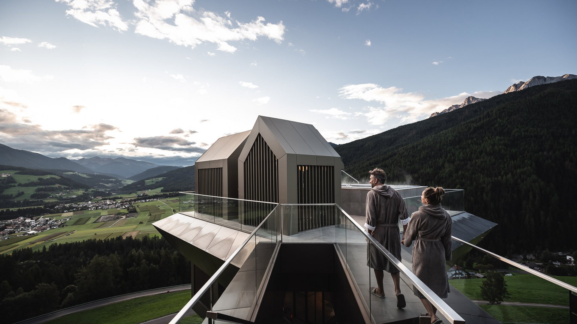 Hotel im Pustertal mit 5 Sternen Paar in Bademänteln auf Dachterrasse mit Bergblick und Sauna im modernen Haus