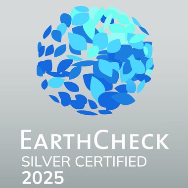 Awards & Press EarthCheck Silber Zertifikat 2025 mit blauem Logo aus Blättern auf grauem Hintergrund