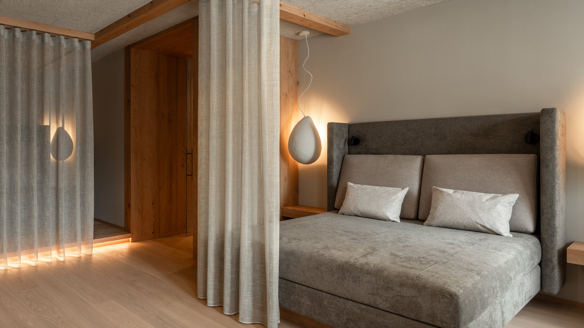 Unsere Sauna, den Kronplatz im Blickfeld Modernes Schlafzimmer mit grauem Bett, Vorhängen und weichen Lampen
