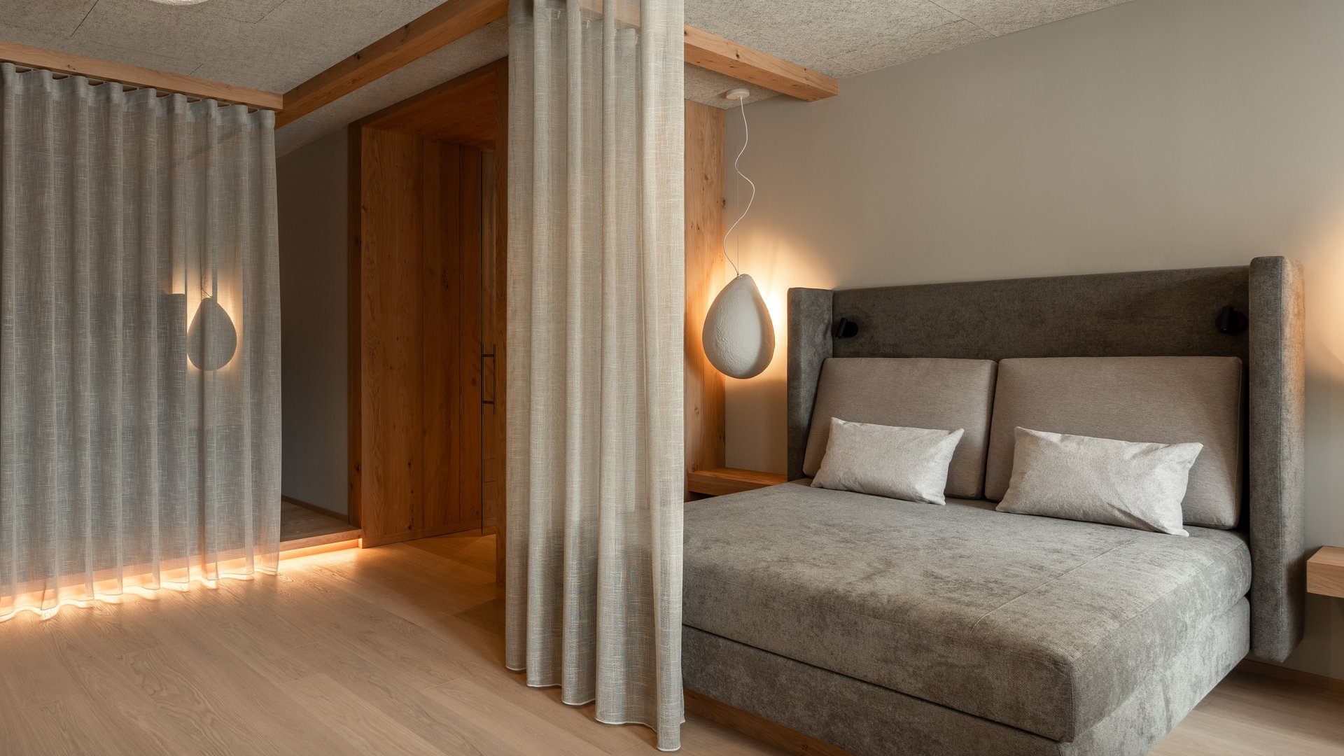 Our sauna, Plan de Corones/Kronplatz in full view Modern bedroom with gray bed, curtains, and soft lighting