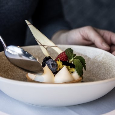 Il regno del gusto Dessert elegante con frutti di bosco e panna in piatto bianco