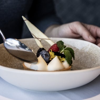 Ein Ort zum Genießen Feines Dessert mit Beeren und Sahne in weißem Teller