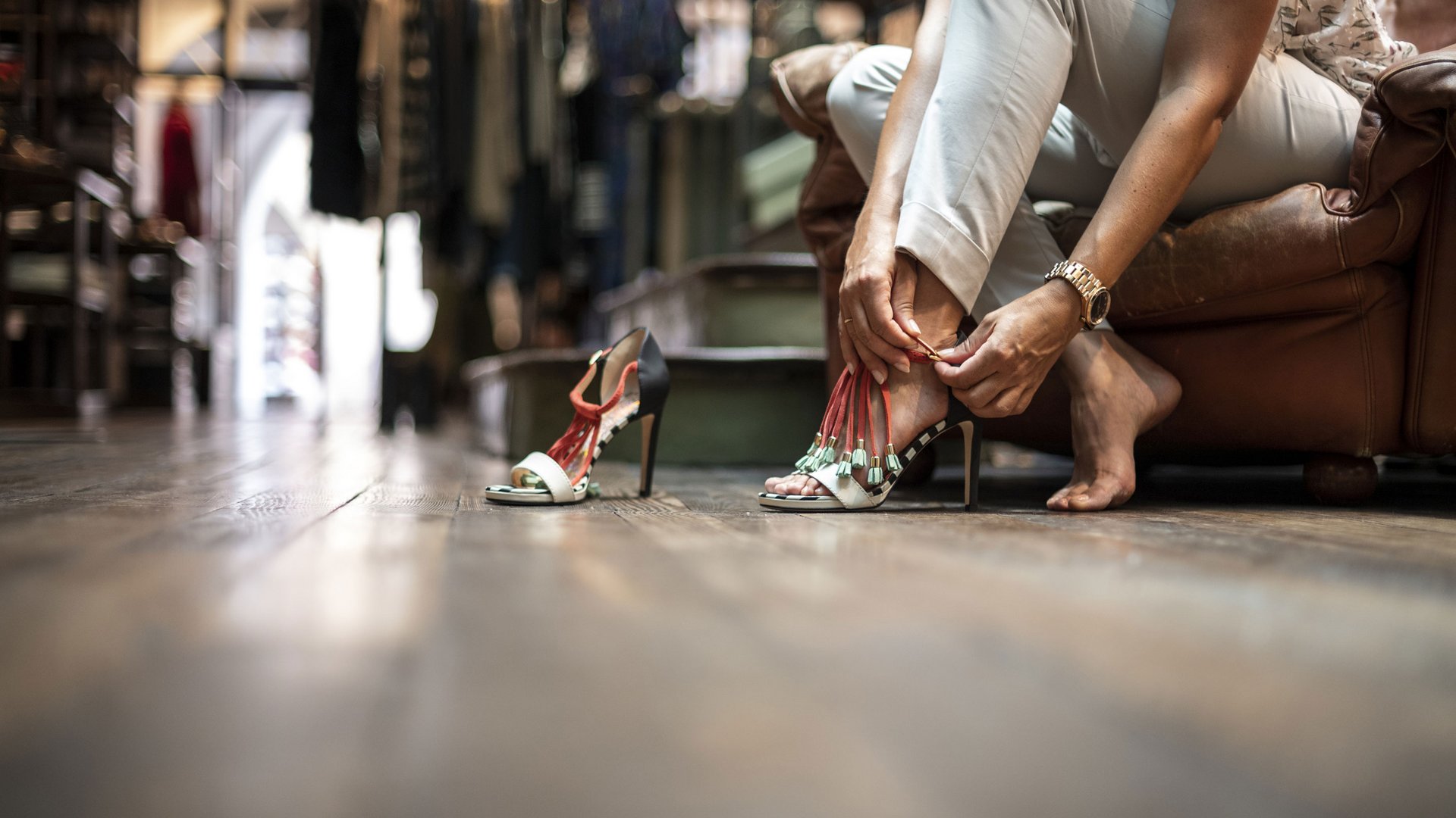 Bruneck: Shopping und mehr Frau sitzt und schnallt stilvolle High Heels an