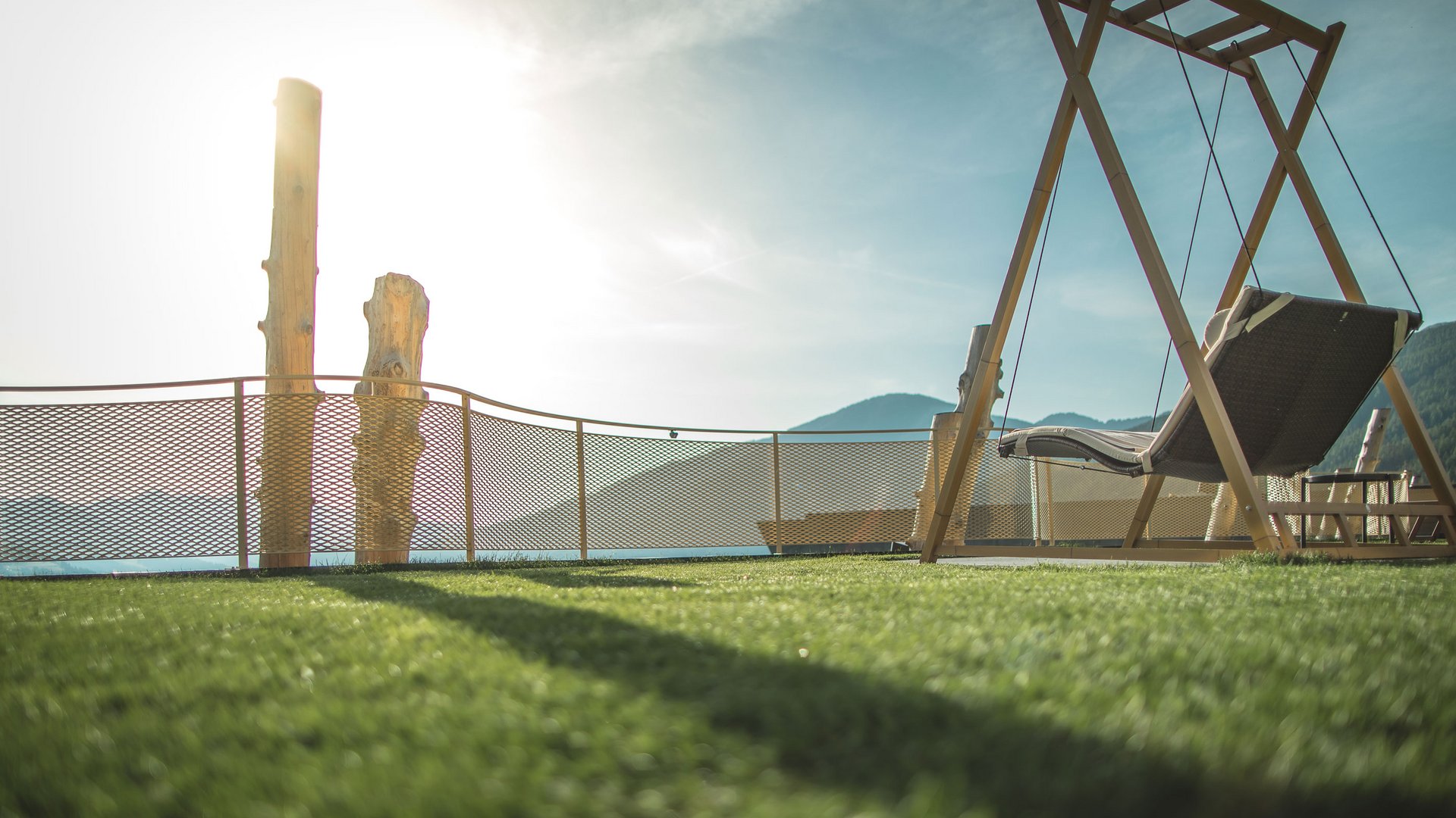 Unsere Parks, Ihre Rückzugsorte Schaukelstuhl auf einer Terrasse mit Bergblick und Sonnenlicht