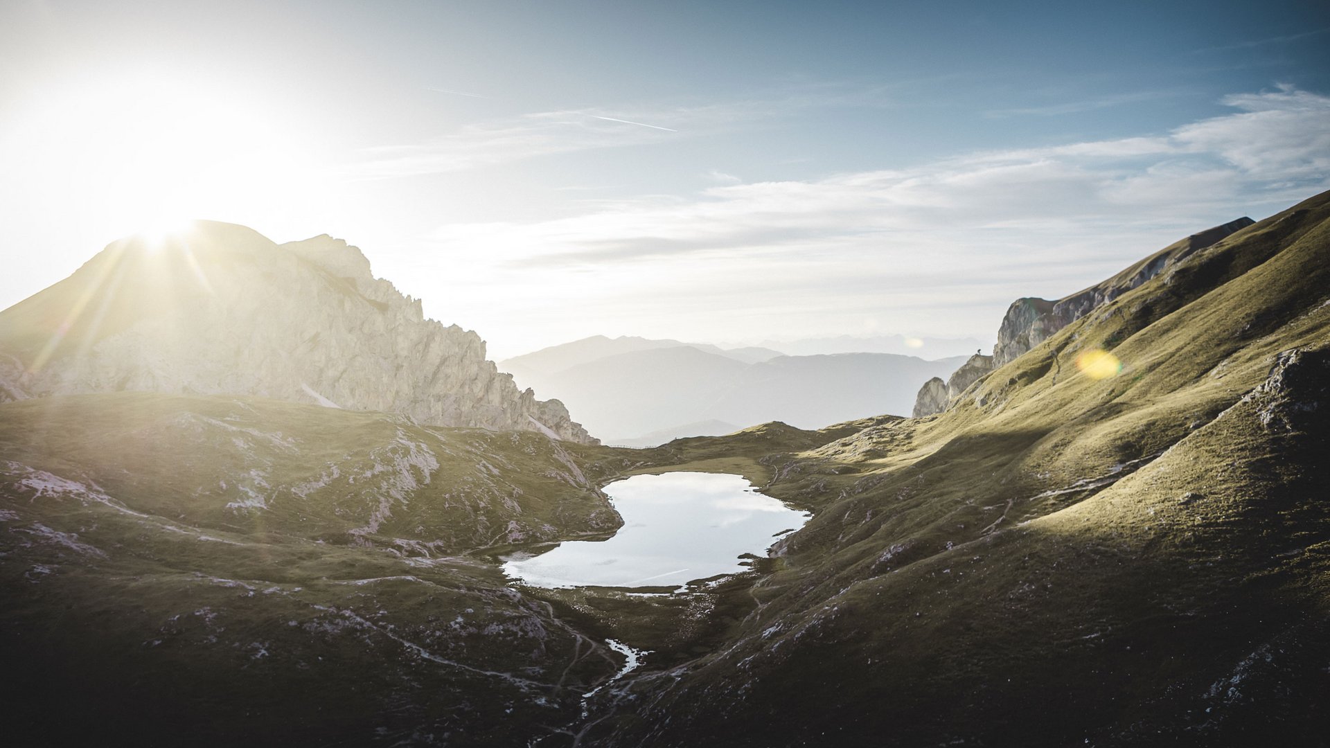 Aktivurlaub in Südtirol: ein Erlebnis Sonnenaufgang über einem Bergsee in einem alpinen Tal