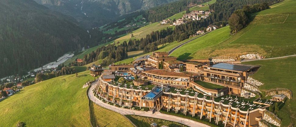 Our 5-star hotel in Italy between heaven and earth Luxury hotel on green hillside with Alpine mountains in the background