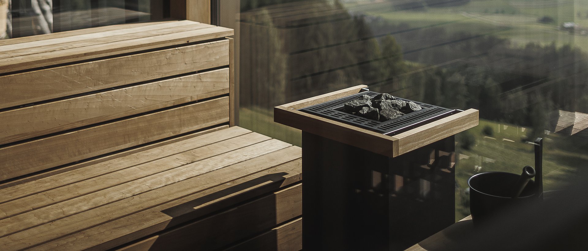 Das Wellnesshotel im Pustertal zum Entspannen Sauna mit Holzbänken und Panoramablick auf Berge und Tal